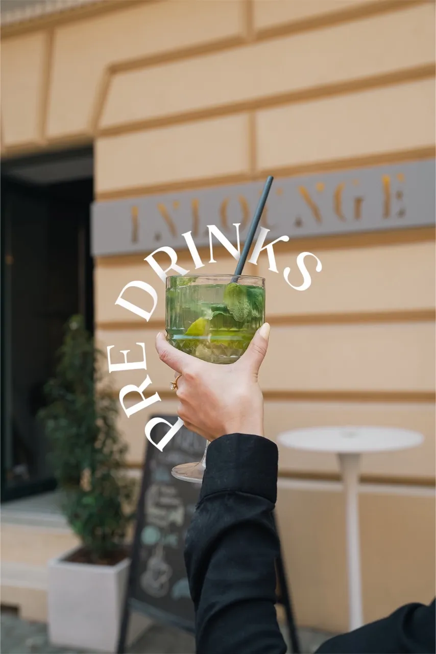 Lifestyle photograph of a green cocktail held outside a lounge